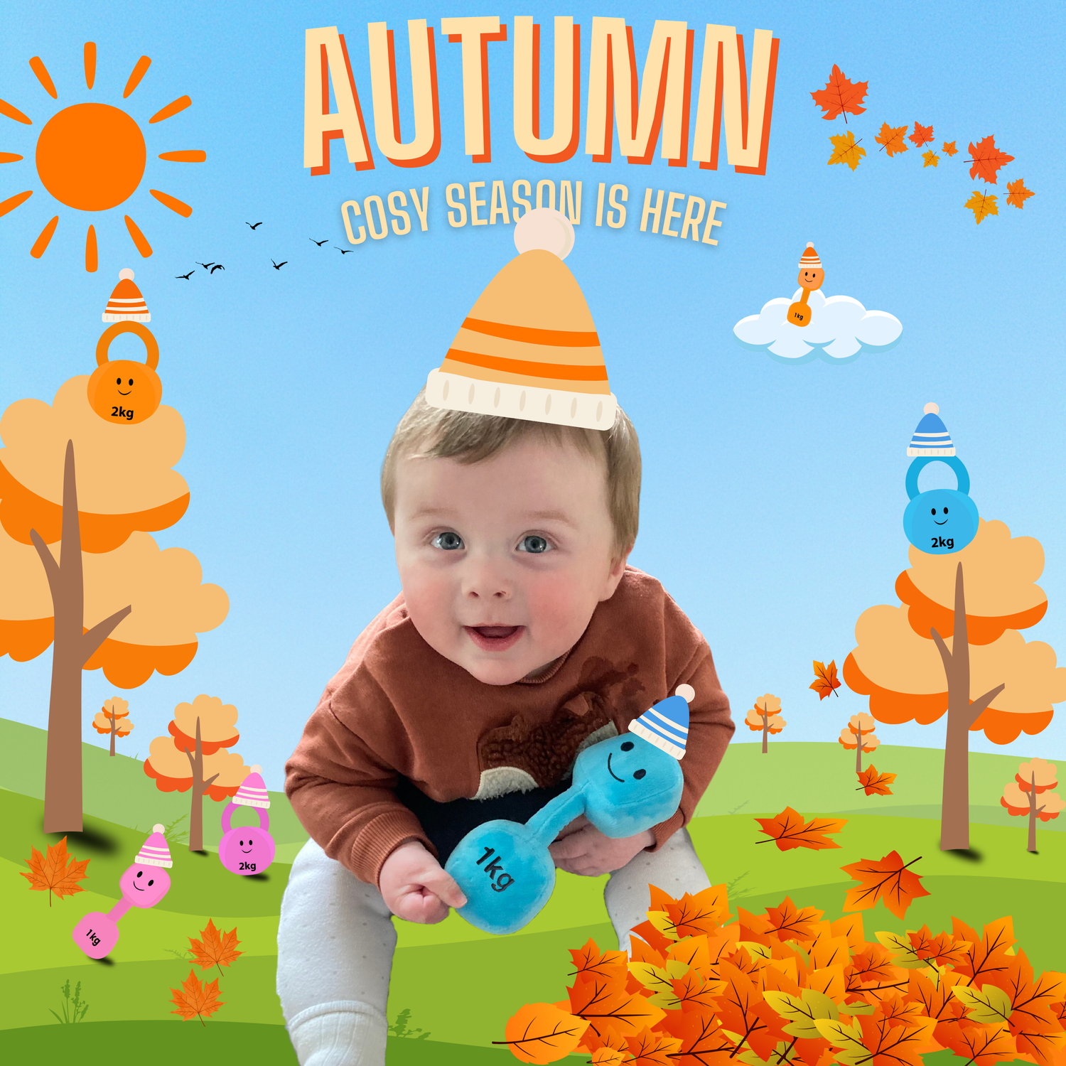 Baby holding a plush dumbbell toy sitting among cartoon autumn trees and falling leaves, with Hazza Toyz gift box and colourful kettlebell characters wearing hats. Autumn seasonal background with sun, clouds, and “Autumn – Cosy season is here” text.