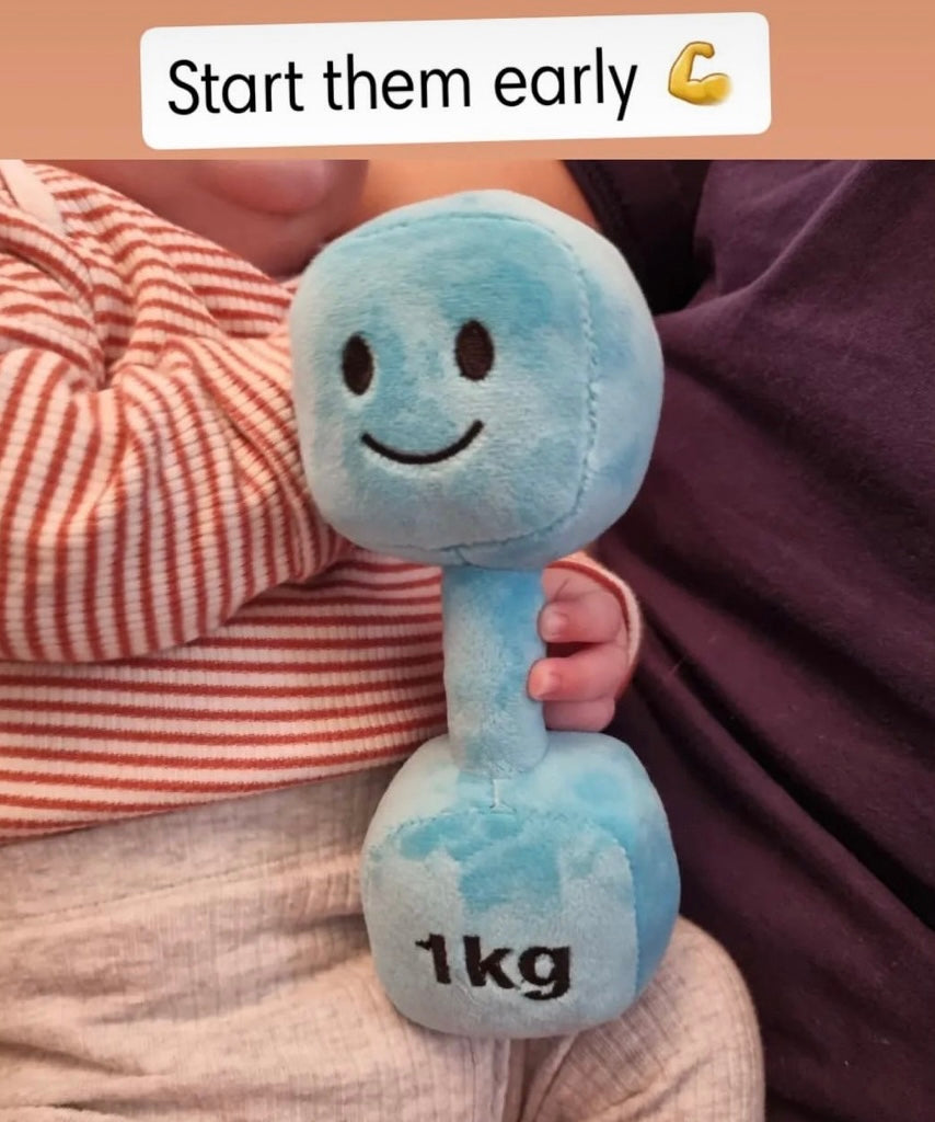 Close-up of baby gripping Mystic Blue Hazza Toyz 1kg plush dumbbell – fun and cheeky gym-themed toy for fitness-inspired baby gifts