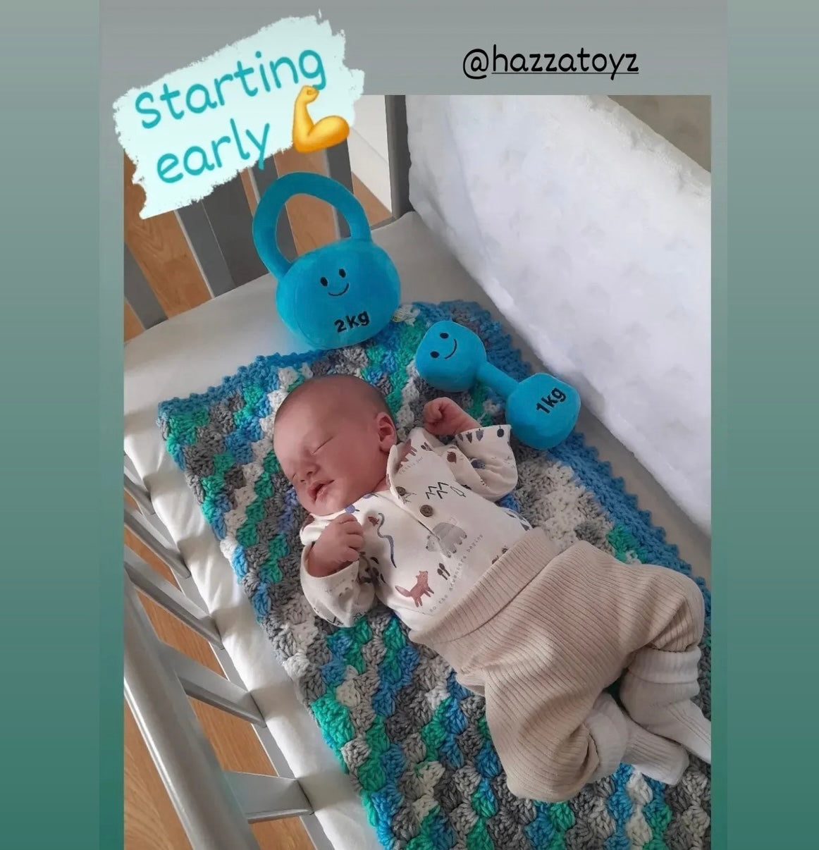 Newborn baby asleep in crib next to Mystic Blue Hazza Toyz plush 1 kg dumbbell and 2 kg kettlebell toys – ideal funny gym‑themed baby gift for fitness parents 