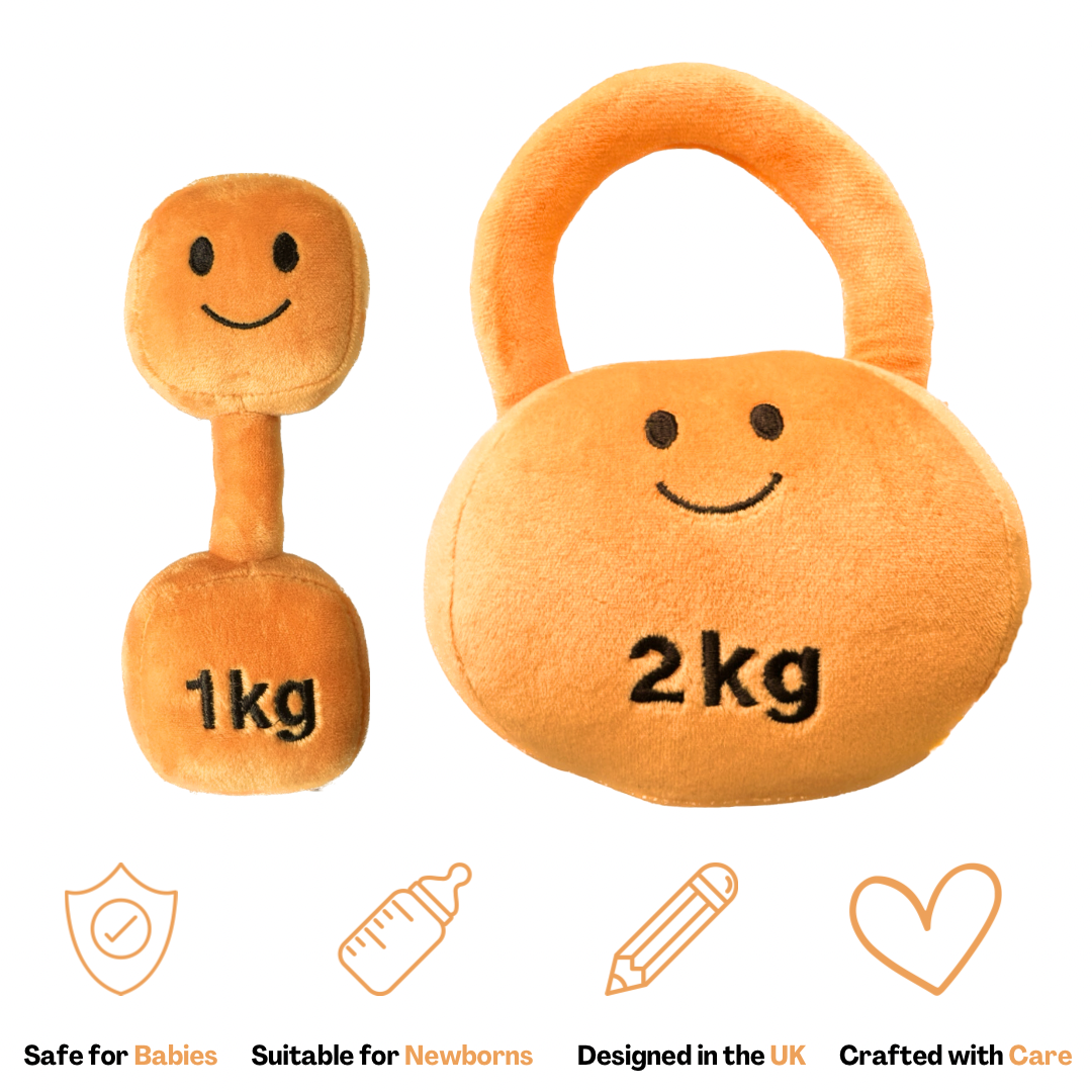 A set of two plush toys designed to look like a dumbbell and a kettlebell, in apricot orange color, with smiling faces on them. The dumbbell is labeled 1kg and the kettlebell is labeled 2kg.