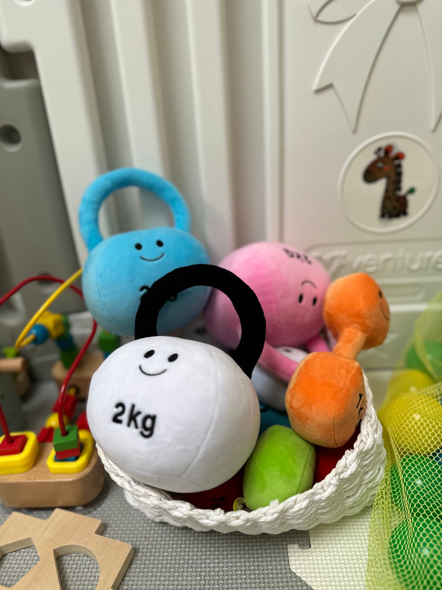 Basket containing kettlebells in all colours: Mystic Blue, Candy Chateau Pink, Lamby Black and White, Apricot Orange, and Lavender Purple, showcasing the vibrant variety of Hazza Toyz fitness-inspired toys for toddlers.