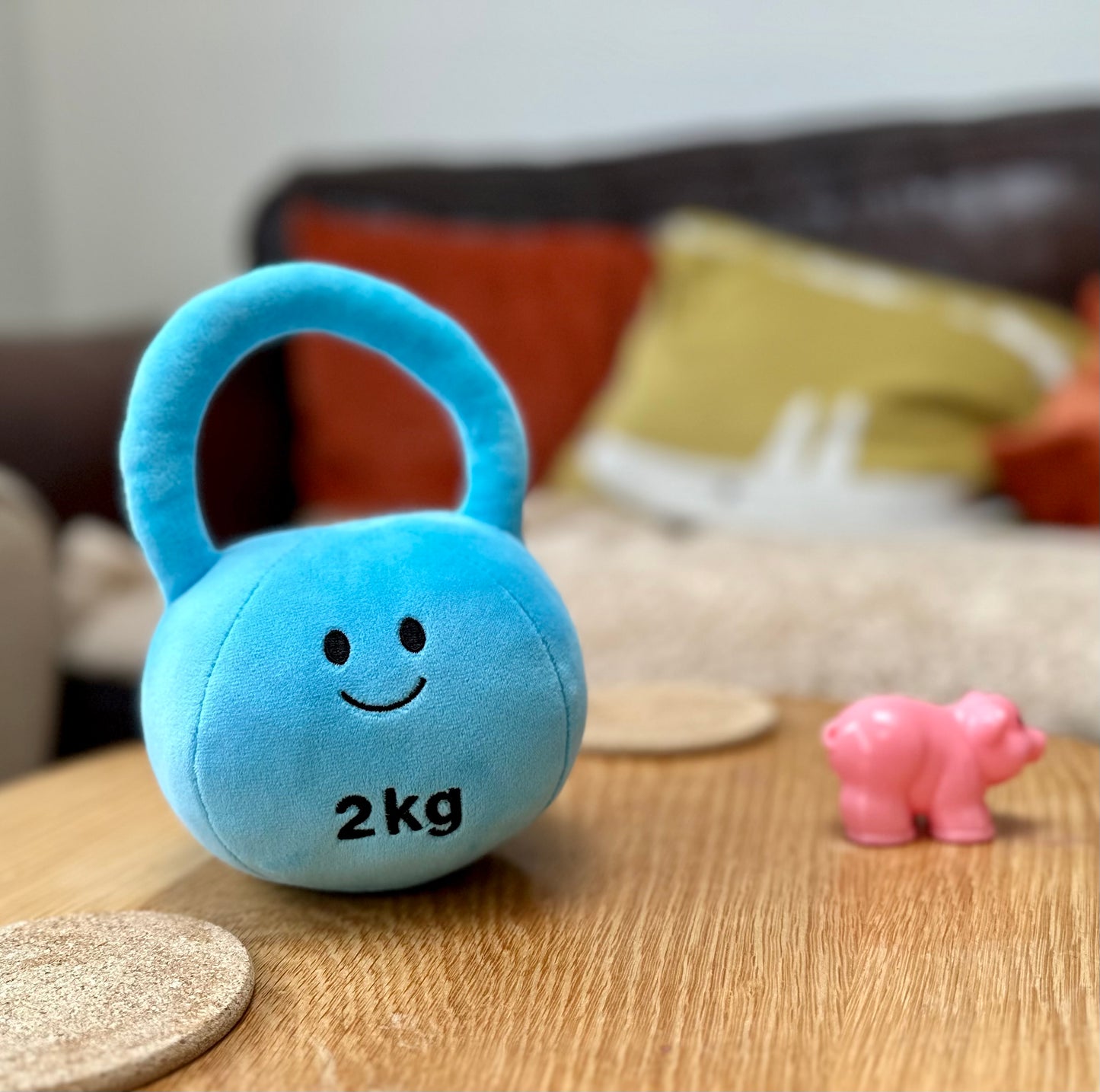 Mystic Blue kettlebell alongside a Candy Chateau Pink plastic toy pig, combining fitness-inspired fun and imaginative play with Hazza Toyz toys for toddlers.