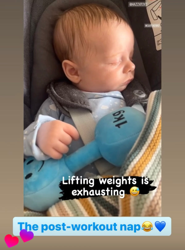 Baby napping in car seat holding Mystic Blue Hazza Toyz 1kg plush dumbbell toy – sweet and funny gym-themed baby gift idea for fitness-loving families
