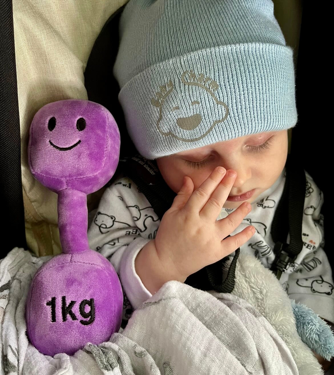 Baby asleep holding Hazza Toyz Lavender Purple dumbbell, providing comfort and sensory relaxation during nap time