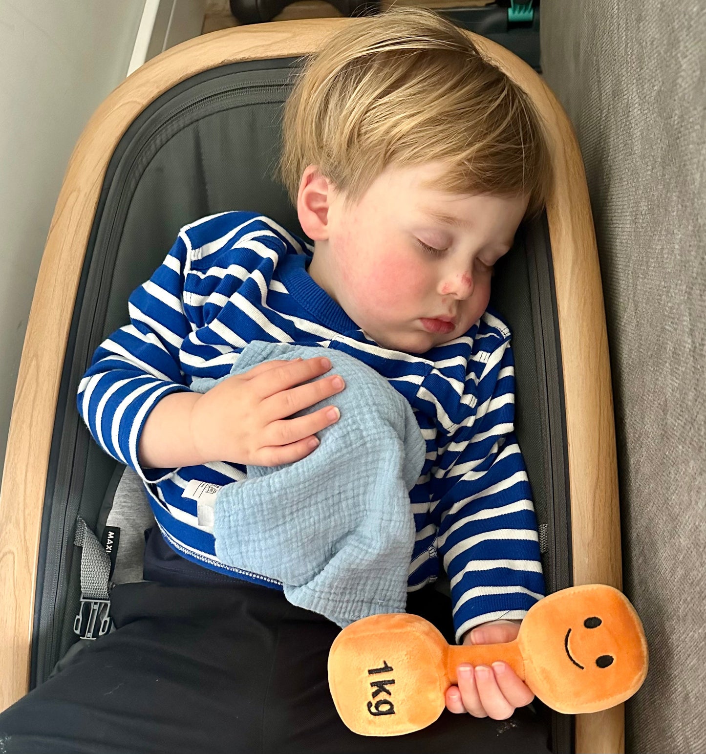 Baby sleeping while holding Hazza Toyz Apricot Orange dumbbell, providing comfort and sensory relaxation during nap time