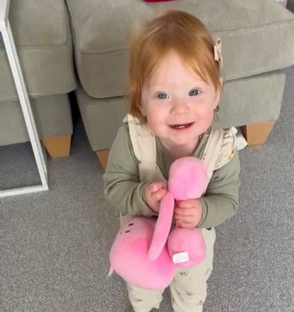 Cute toddler holding Hazza Toyz Candy Chateau Pink dumbbell and kettlebell, smiling at camera, enjoying playful sensory interaction