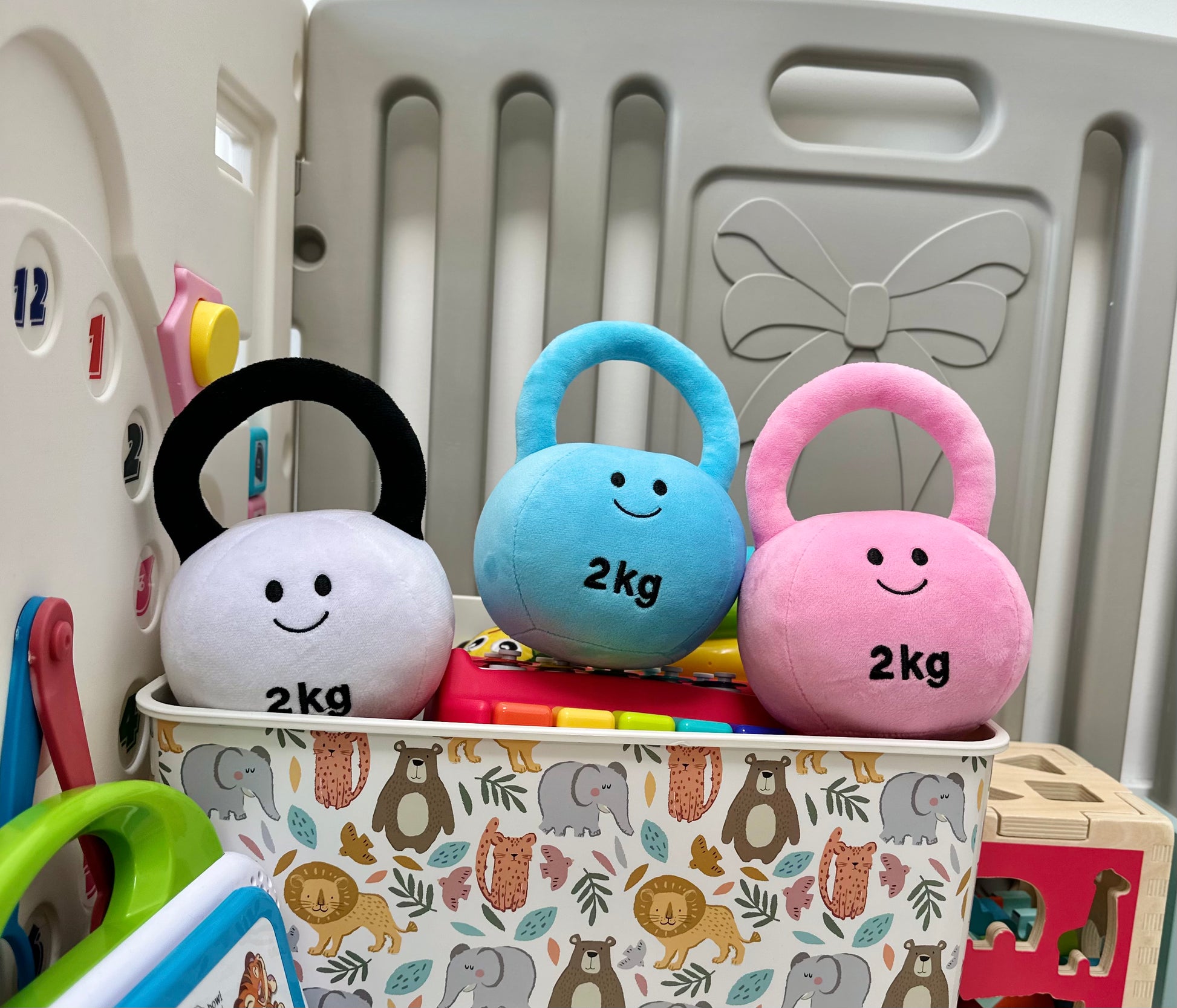 Hazza Toyz kettlebells in Lamby Black and White, Candy Chateau Pink, and Mystic Blue on playmat, arranged for sensory play and motor skill development