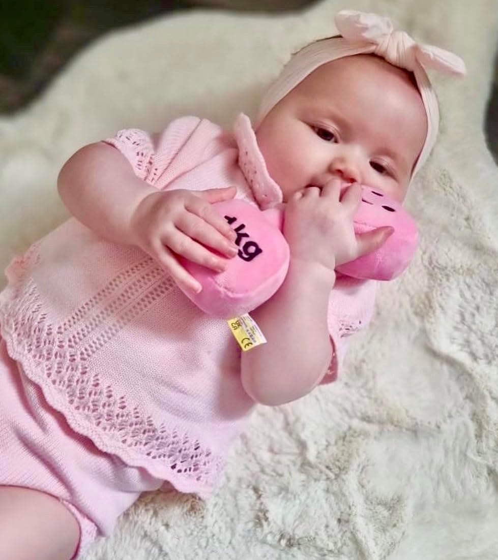 Baby girl cuddling a Candy Chateau Pink dumbbell, enjoying a cosy and playful moment with Hazza Toyz fitness-inspired toys for toddlers.