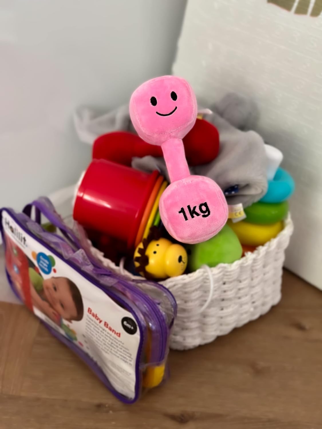 Candy Chateau Pink dumbbell resting on top of other toys in a basket, showcasing Hazza Toyz fitness-inspired toys as part of a colourful play collection for toddlers.