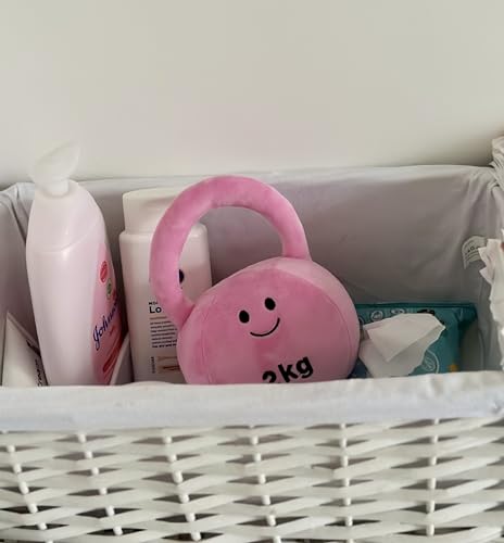 Hazza Toyz Candy Chateau Pink kettlebell surrounded by other pink baby items like wipes, creating a coordinated and playful arrangement