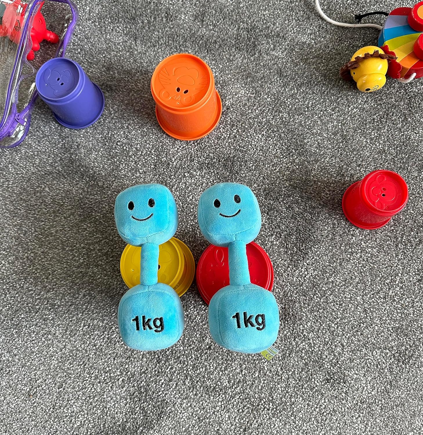 Two Mystic Blue dumbbells surrounded by other toys, showcasing a playful setup with Hazza Toyz fitness-inspired toys for toddlers.