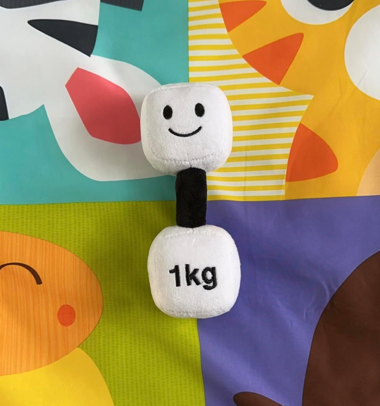 Lamby Black and White dumbbell set against a colourful background, highlighting the vibrant and playful design of Hazza Toyz fitness-inspired toys for toddlers.