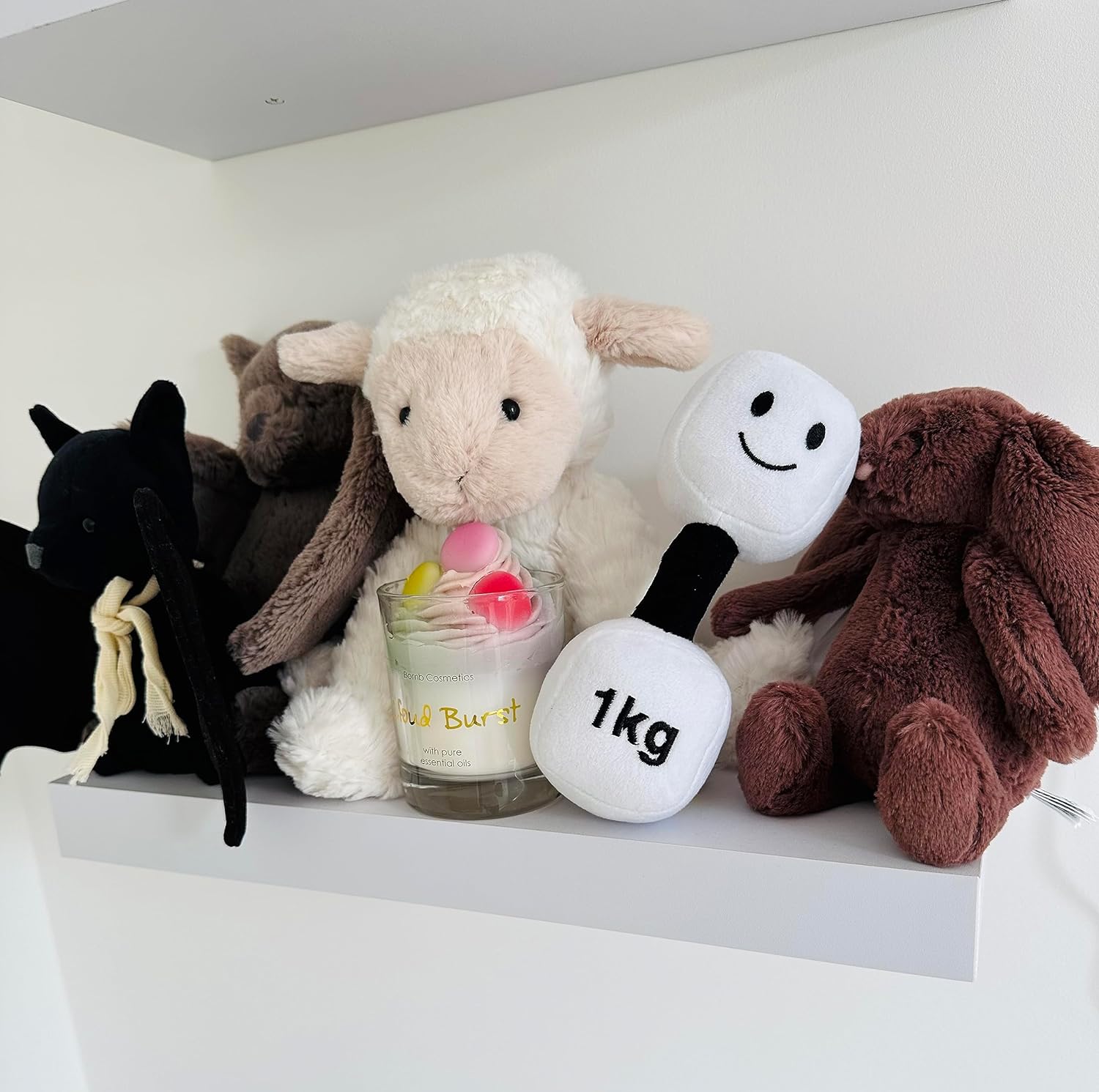 Lamby Black and White dumbbell on a shelf alongside baby toys, adding a playful touch to nursery decor with Hazza Toyz fitness-inspired toys for toddlers.